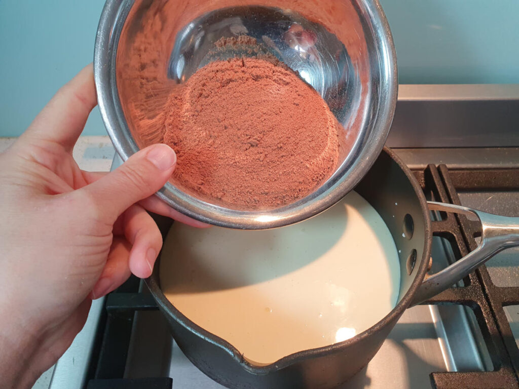 adding milo to ice cream mix in pot.