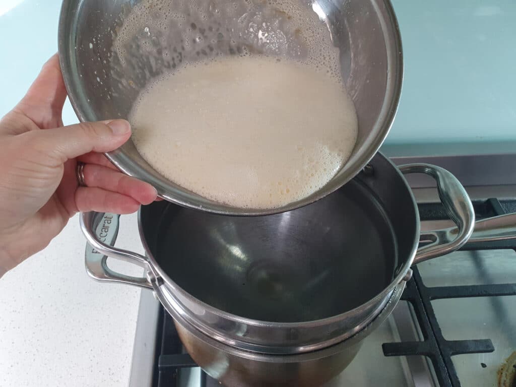 adding yolk, sugar and milk mix to top of double boiler