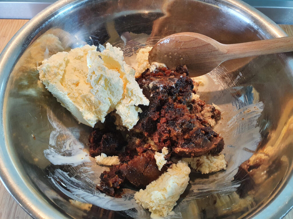 Christmas pudding ice cream 6 adding more vanilla ice cream to pudding mix in bowl.