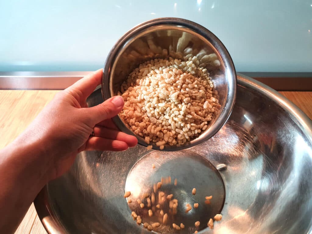 adding rice bubbles to mix in bowl.