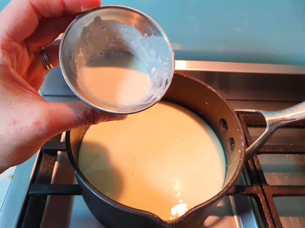 adding milk and tapioca starch slurry to ice cream min in pot on stove.