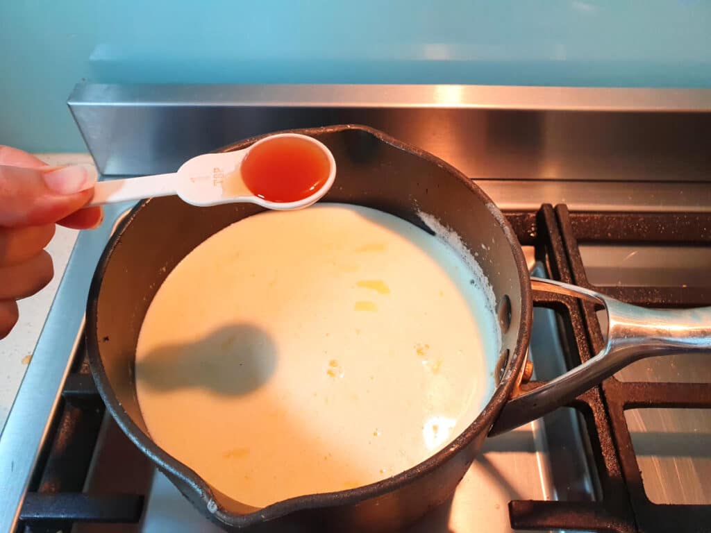 adding vanilla to ice cream mix in pot on stove.