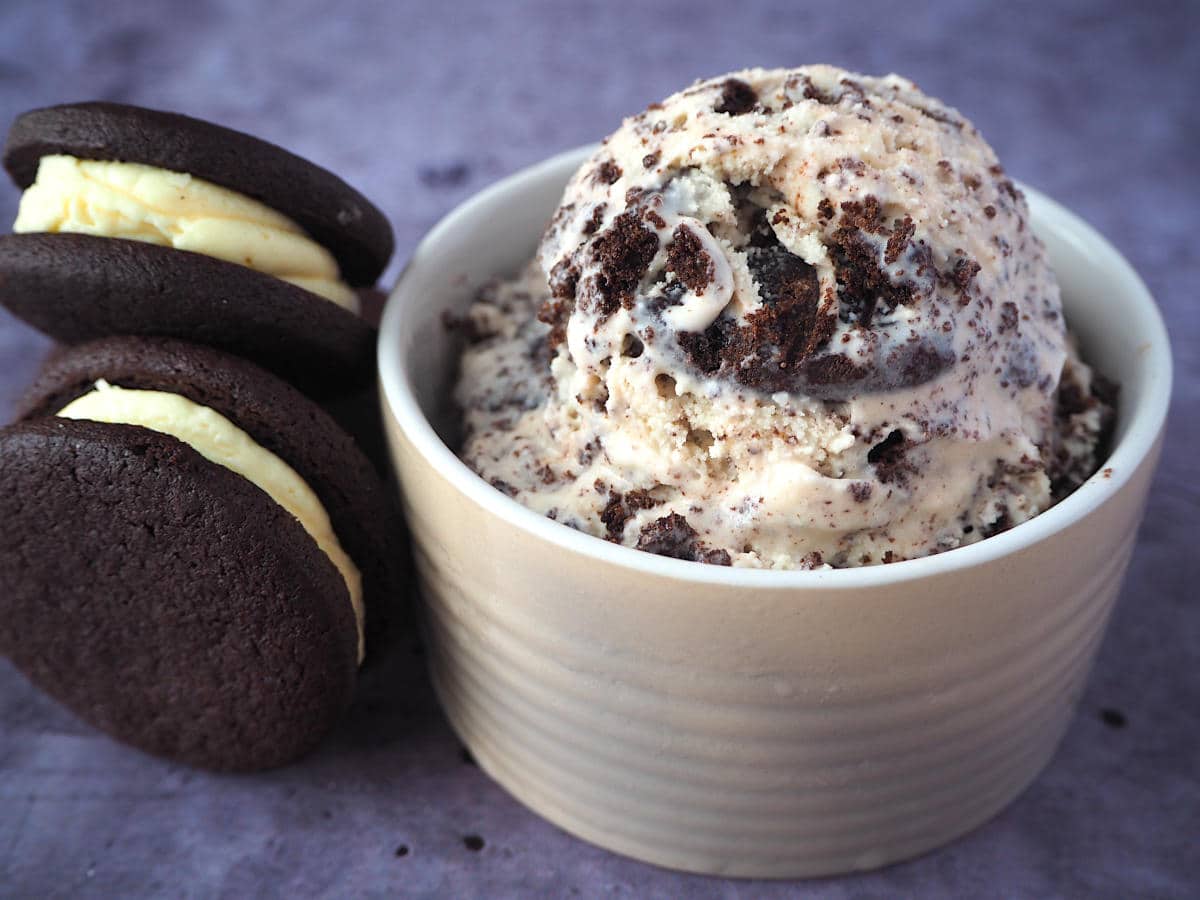 Bowl of cookies and cream ice cream with Oreos stacked on the side.