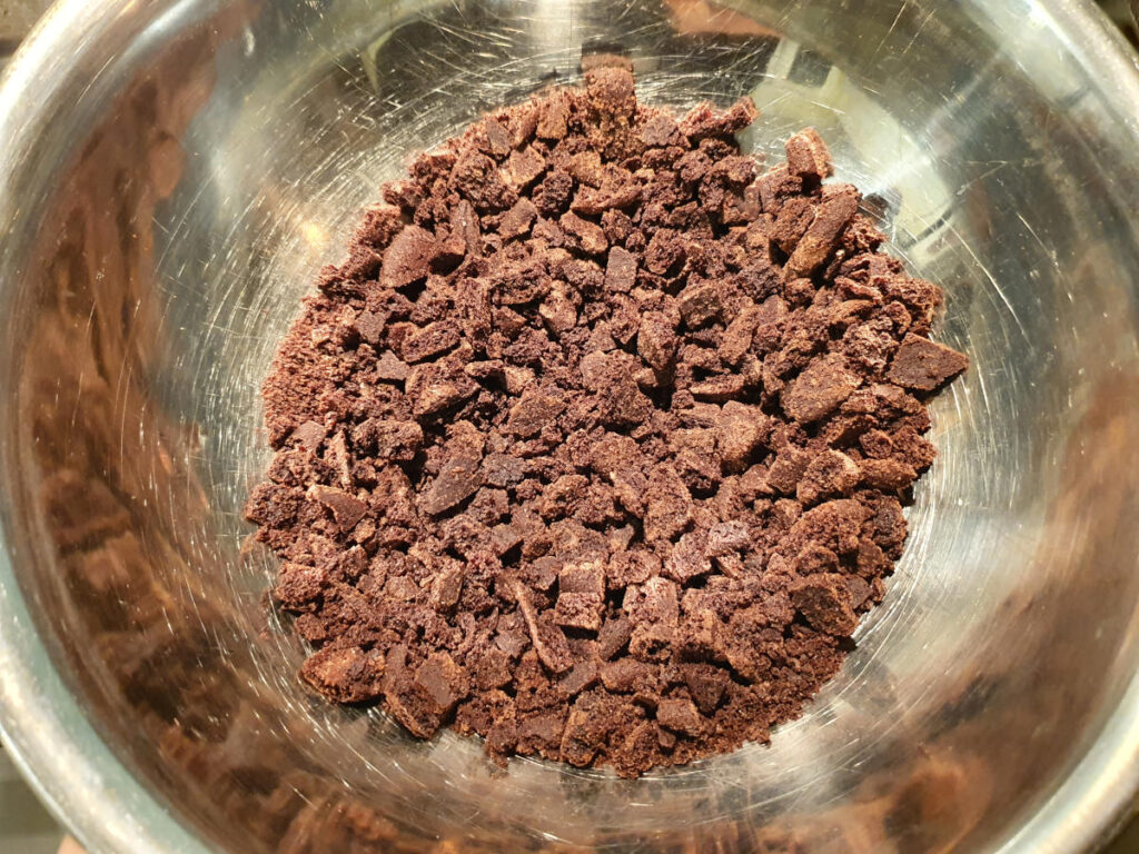 Oreos crushed up quite fine in a bowl, with pieces ¼ inch big or smaller.