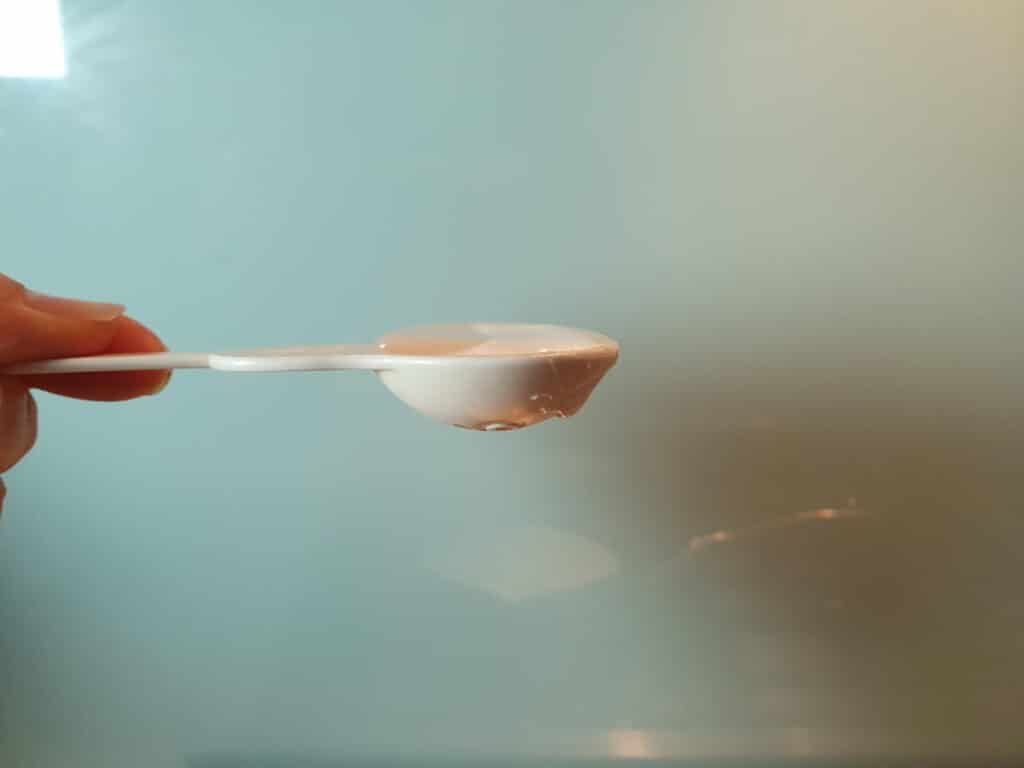 side view of half table spoon measure showing flat table spoon of glucose syrup measured out.