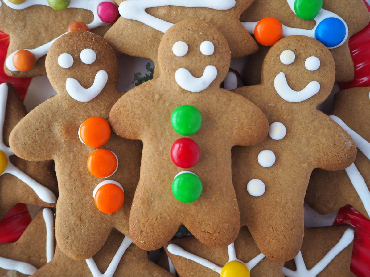 close up of three gingerbread men surrounded by other decorated gingerbread.