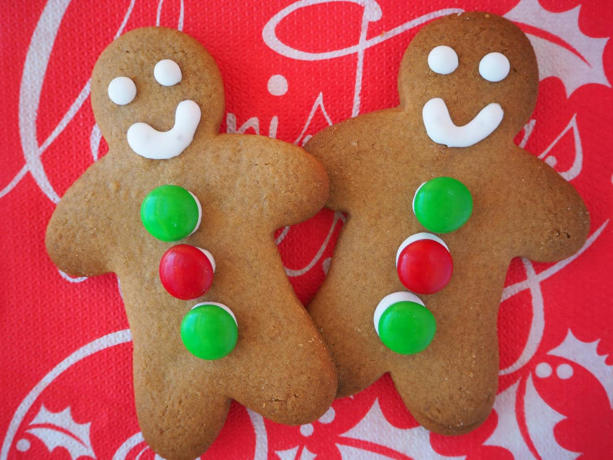 pair of decorated gingerbread med on a red Christmas serviette.