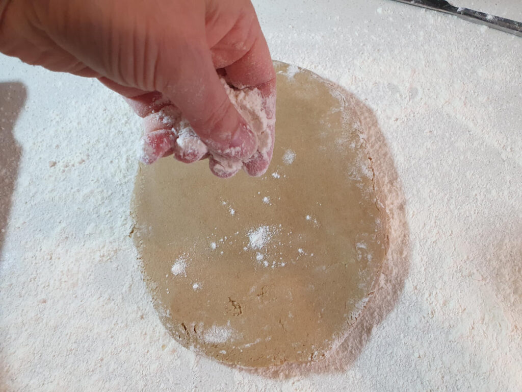 sprinkling more flour on dough to prevent rolling pin sticking.