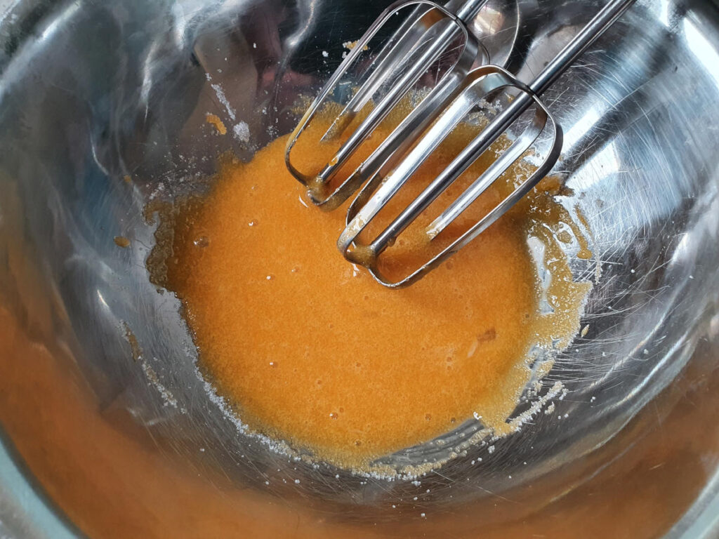 bright yellow color of egg yolks and sugar just starting to be beaten.