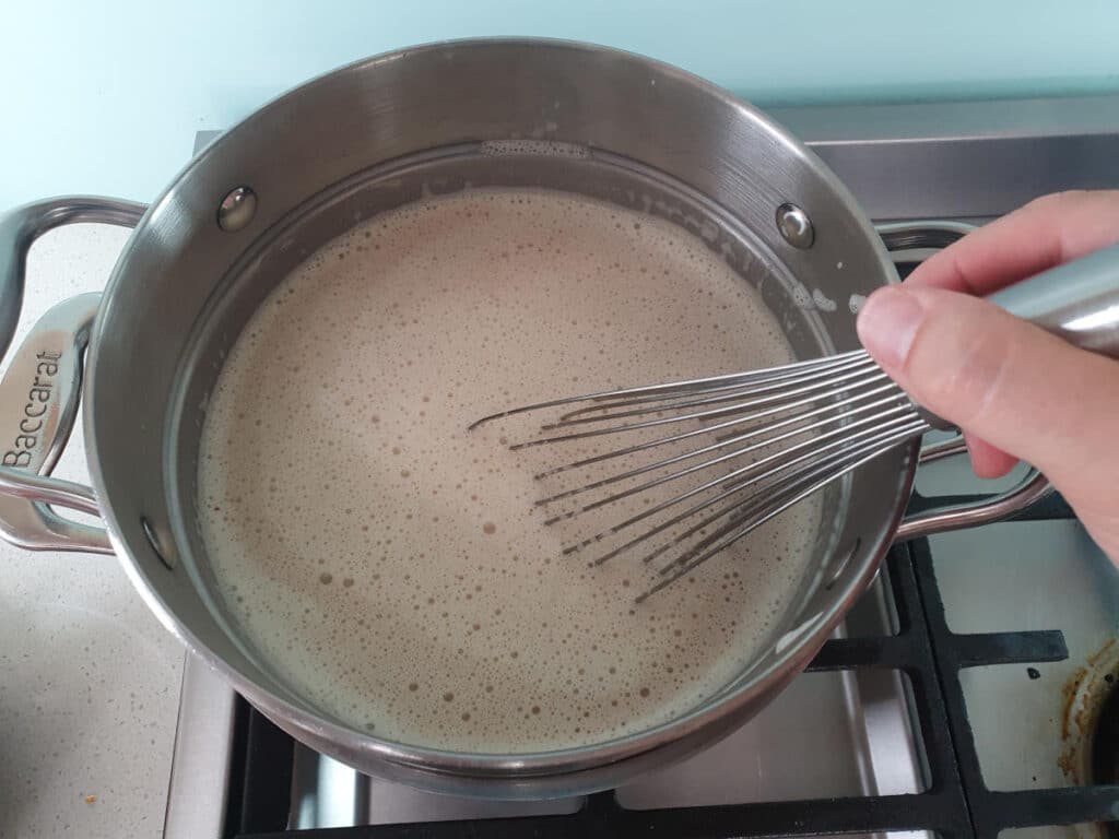 whisking melted milk chocolate into ice cream mix in double boiler.