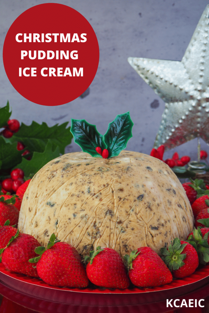 Christmas pudding ice cream with holly garnish, surrounded by fresh strawberries, with holly and a Christmas star in the background and text overlay, Christmas pudding ice cream and KCAEIC.