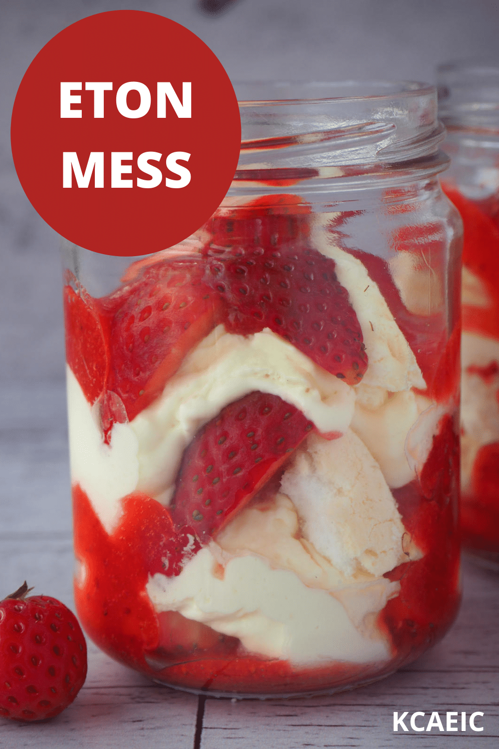 Two jars of Eton mess with fresh strawberries on the side with text overlay, Eton mess, KCAEIC.