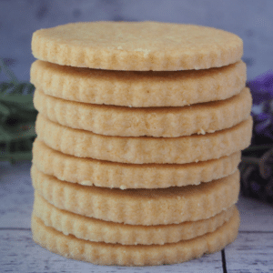 Close up side view of stack of gluten free short bread with fresh lavender in the background.