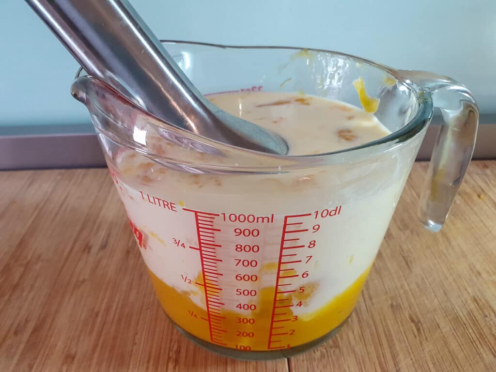 Blending mango puree and rest of ice cream mix together with a stick blender.