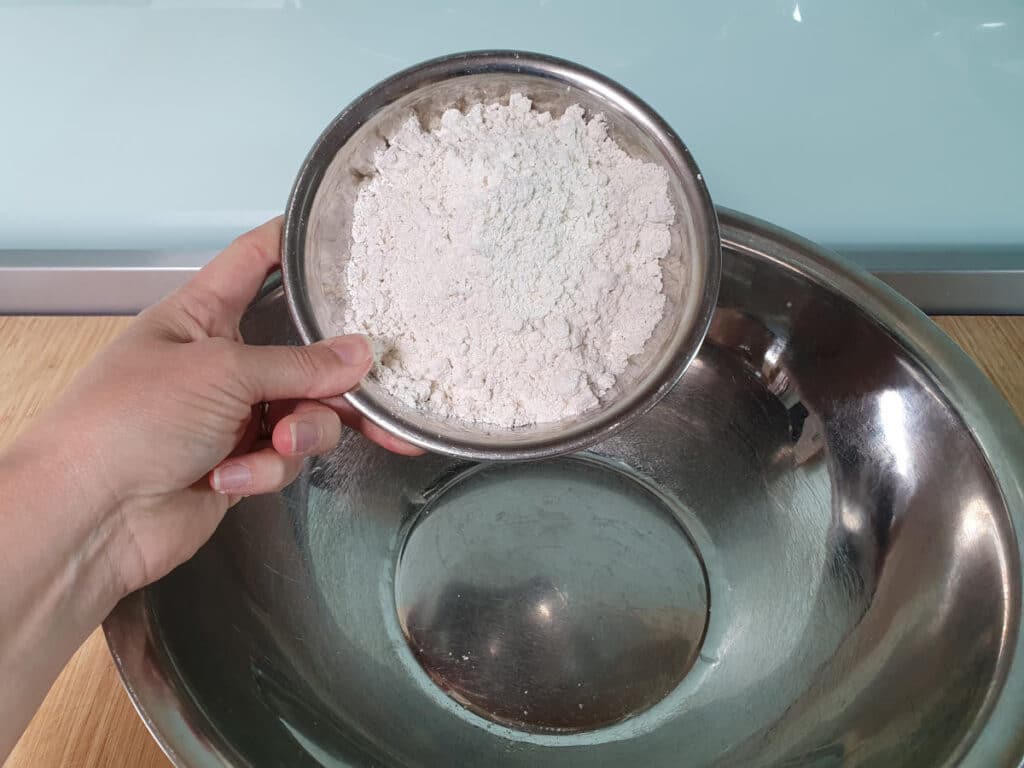 adding gluten free flour to bowl.