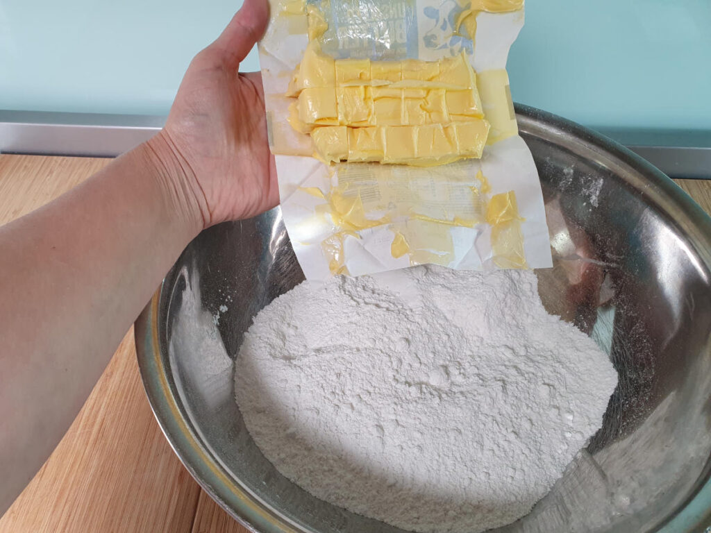 adding room temperature, cubed butter to shortbread mix.