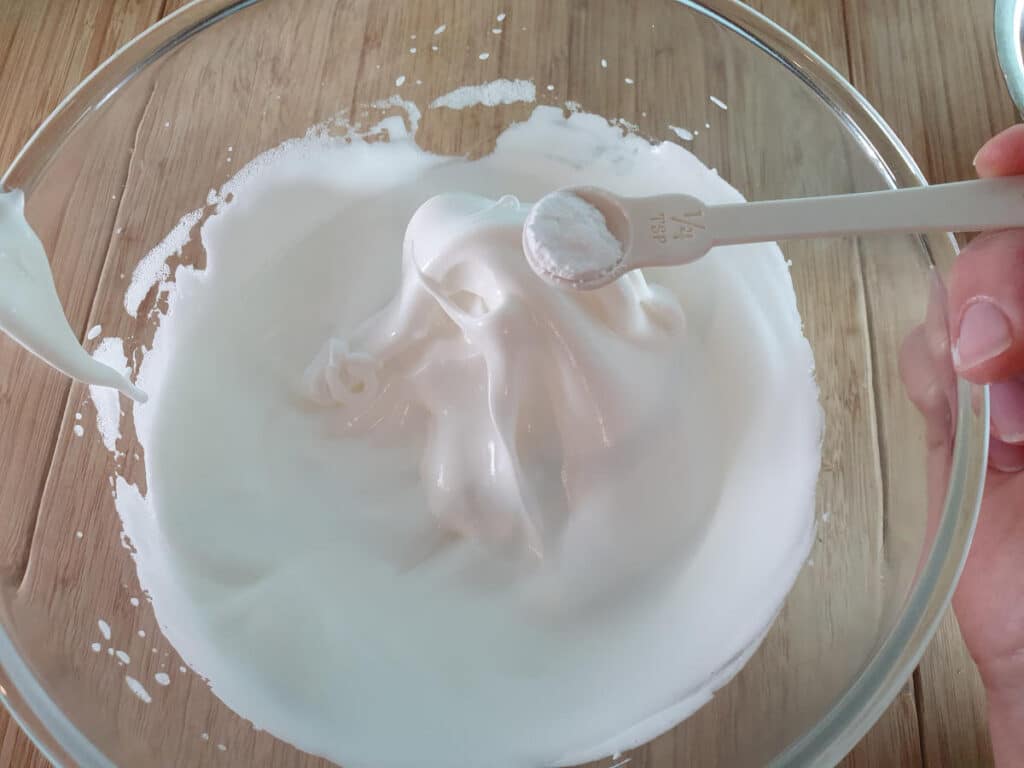 adding cream of tartar to whipped egg whites.