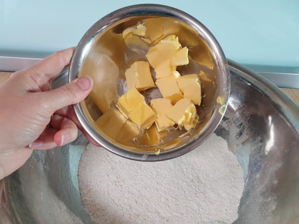 adding cubed butter to dry ingredients.