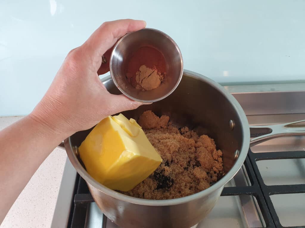 adding spice mix to pot on stove.