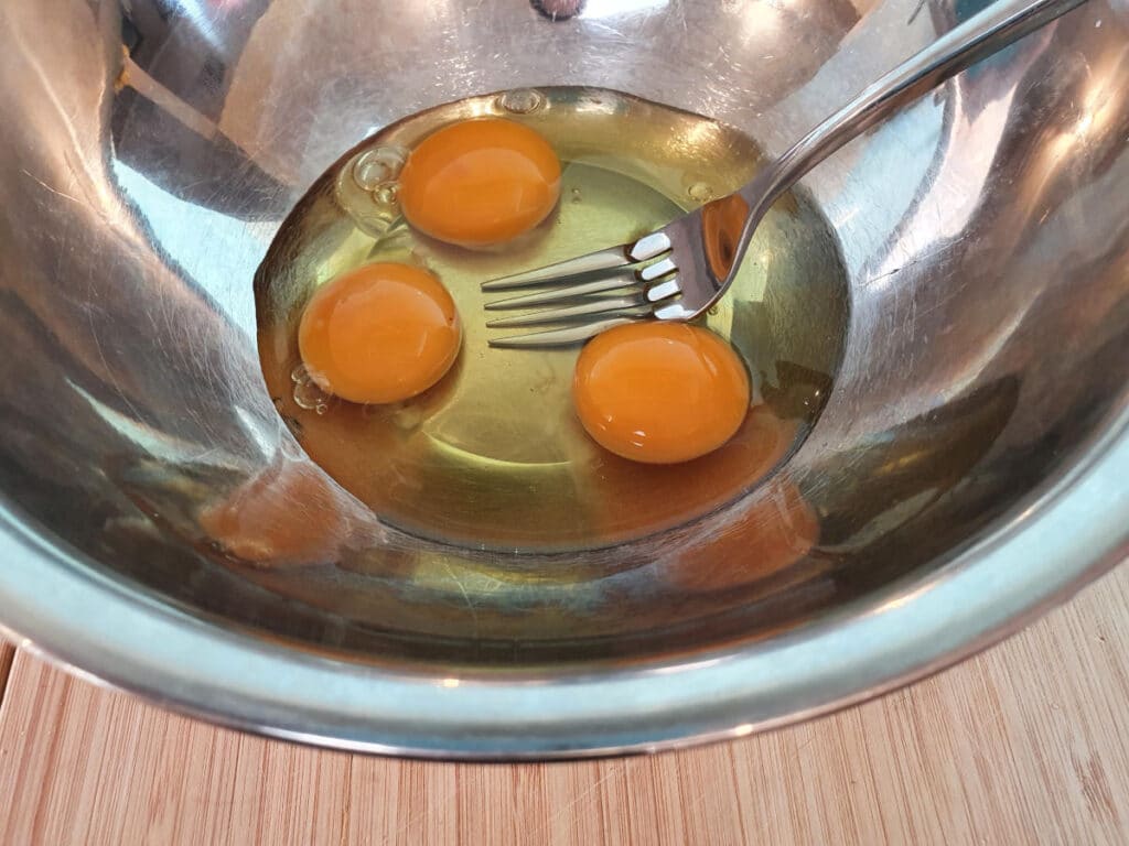 lightly beating eggs in bowl.
