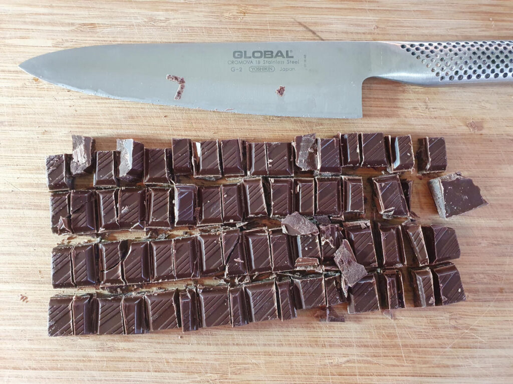 chopping up chocolate with a sharp knife.