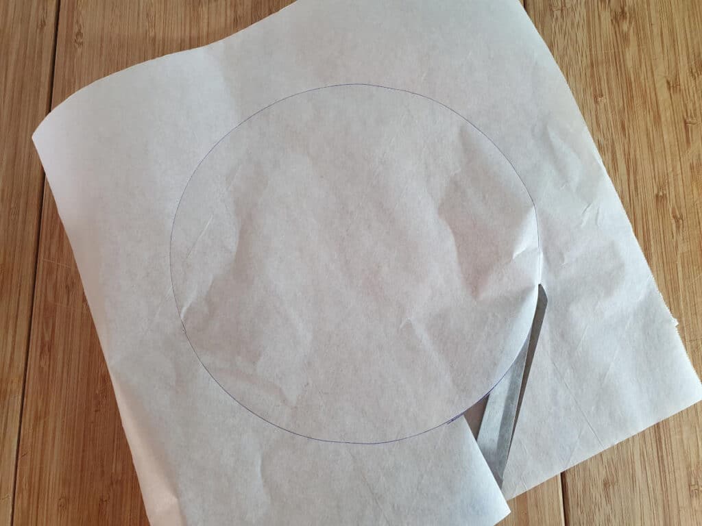 cutting out traced cake tin circle.