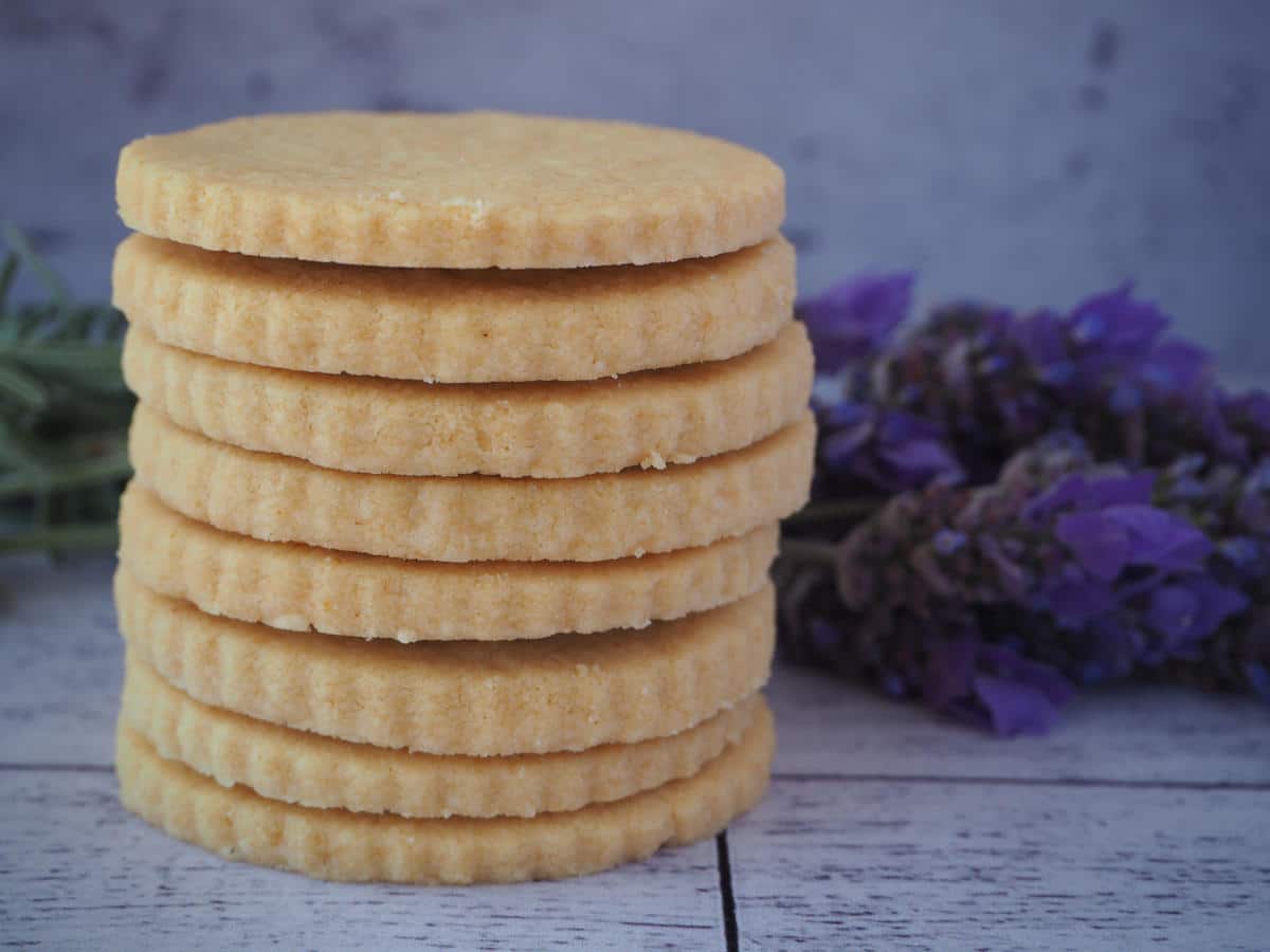 Gluten free shortbread 2 side view of stack of gluten free short bread with fresh lavender behind it.
