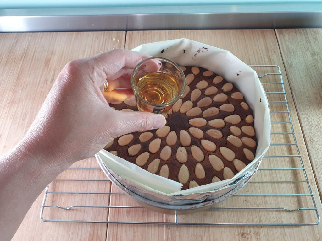 pouring brandy over cooked cake.