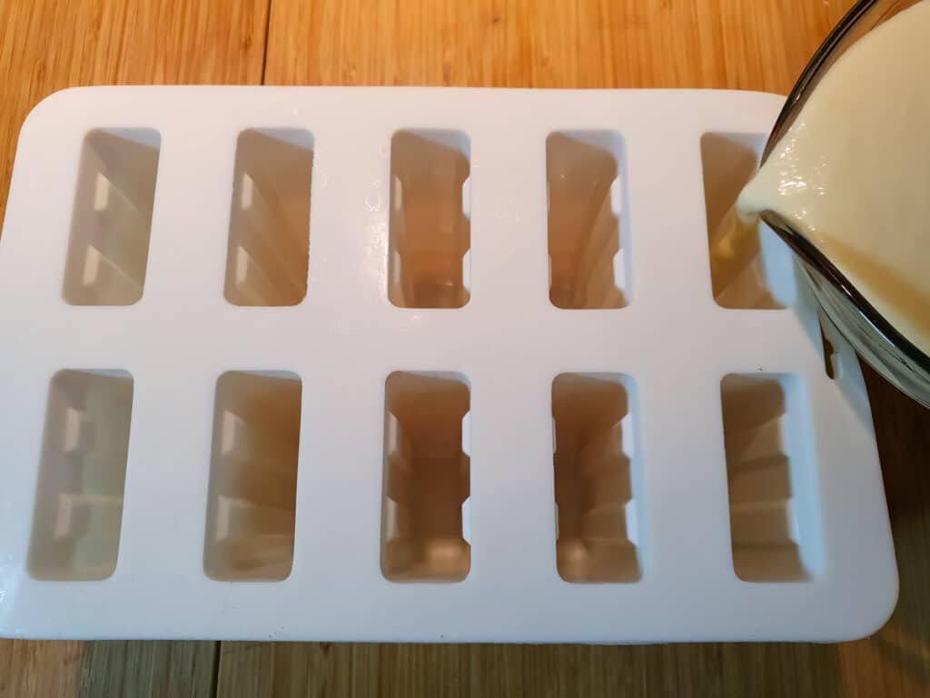 Filling molds with popsicle mix.