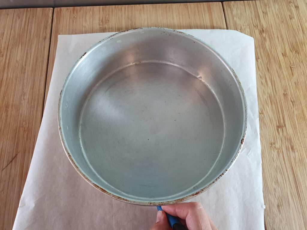 tracing cake tin shape onto baking paper with a pen.