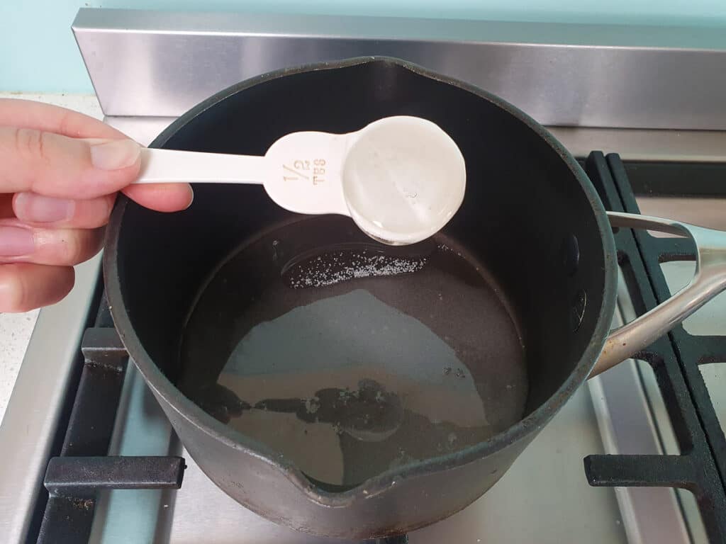 Adding glucose syrup to pot for strawberry sauce.