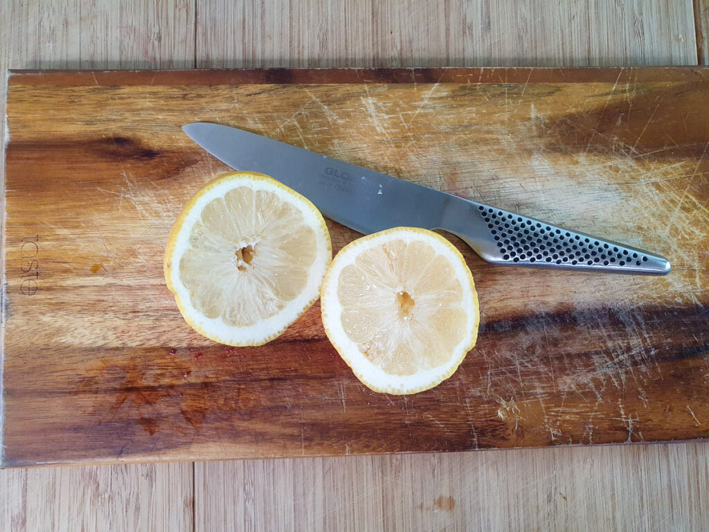 Slicing lemons to juice for strawberry sauce.