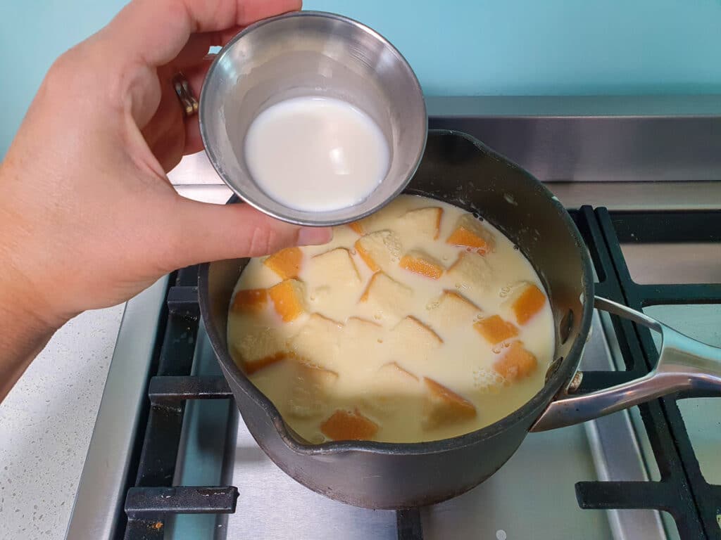 Adding tapioca starch slurry to ice cream mix in pot.