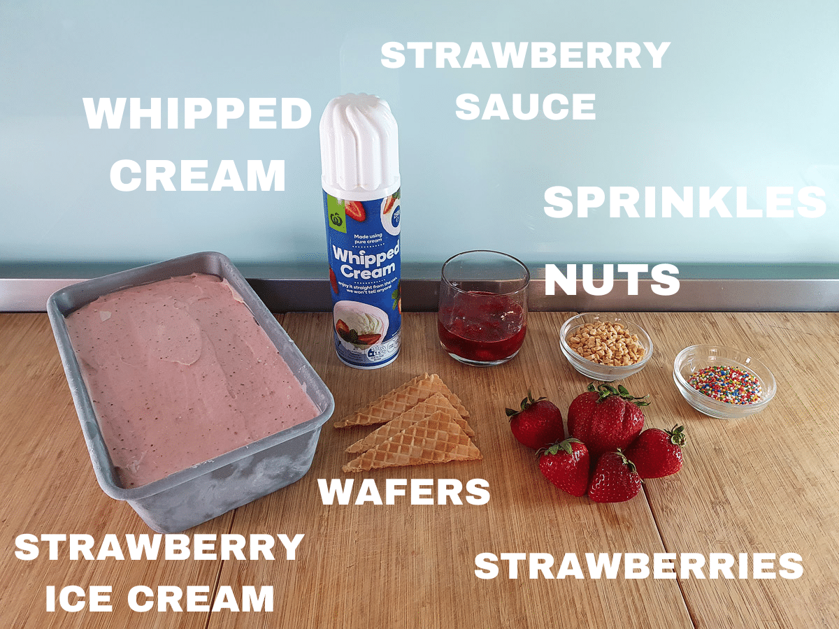 Strawberry sundae ingredients, strawberry ice cream, whipped cream, wafers, strawberry sauce, nuts, sprinkles, fresh strawberries.