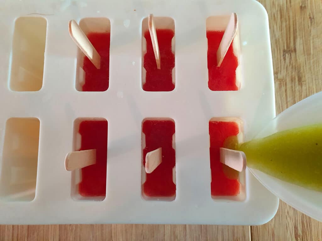 Adding kiwi fruit layer on top of frozen watermelon layer.