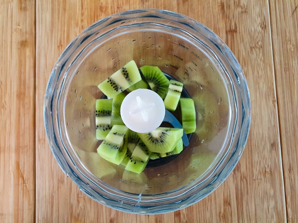 Kiwi fruit chunks in processor ready to blitz.