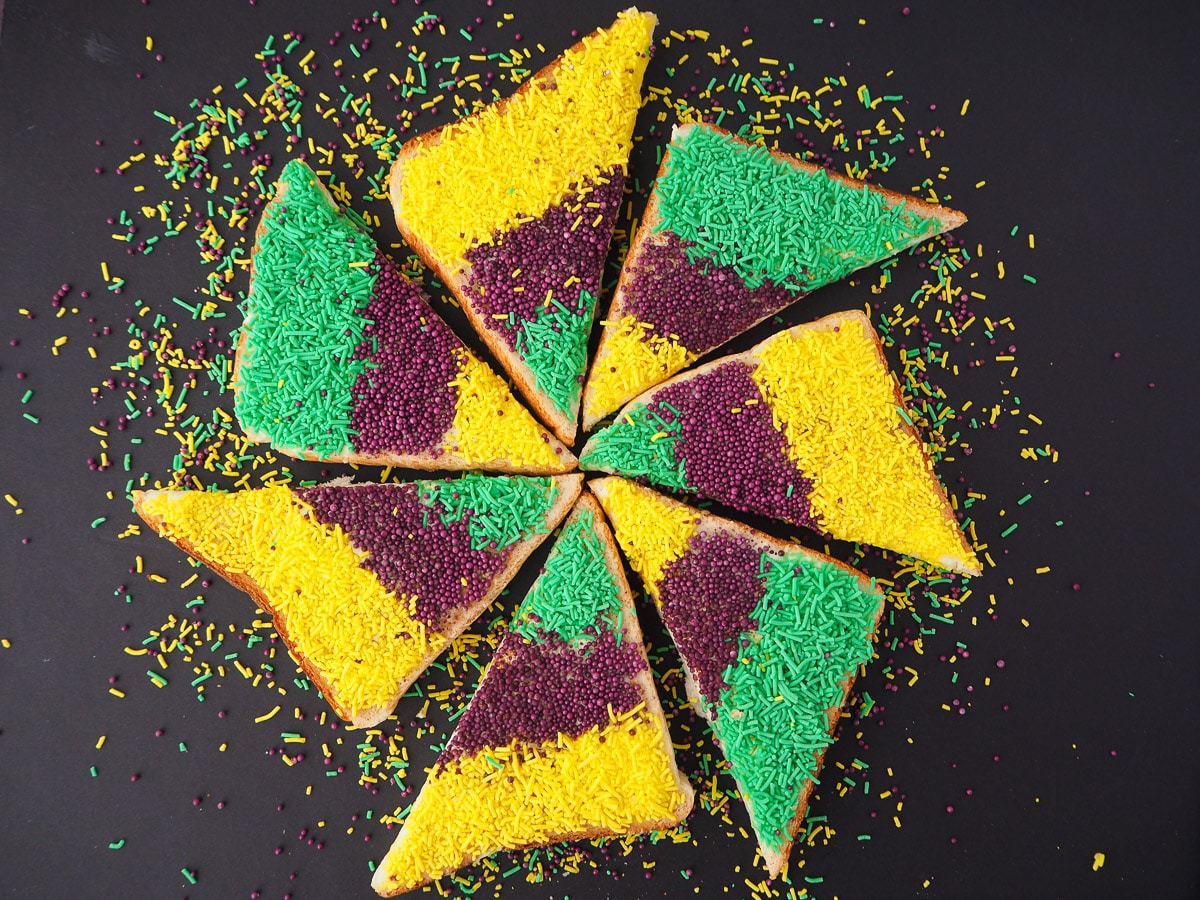 King cake sprinkles bread 2 Several slices of triangle cut King cake sprinkles bread, arranged in a star shape.