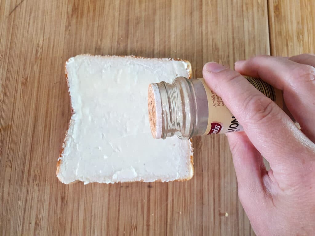 Sprinkling cinnamon over bread.