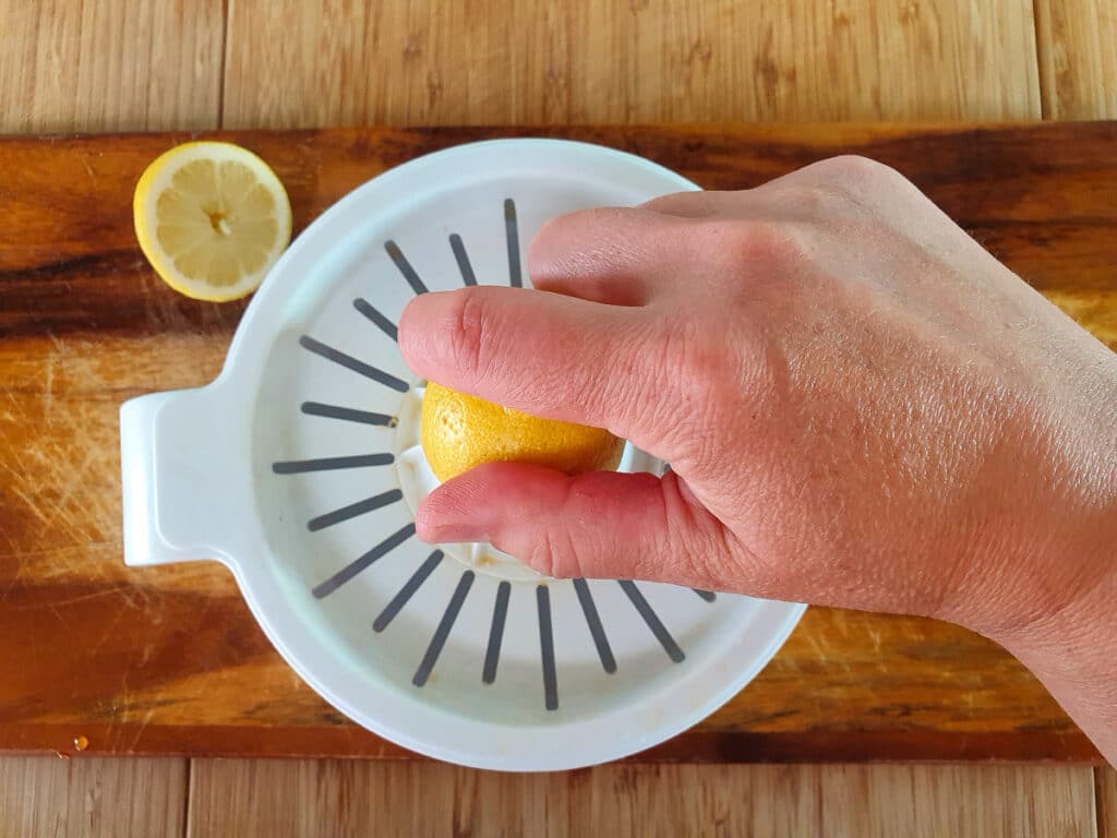 Squeezing lemons with a lemon juicer.