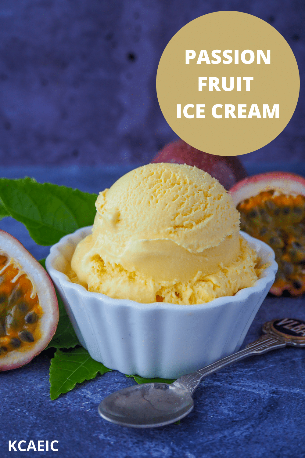 Scoop of passion fruit ice cream with fresh passion fruit and passion fruit leaves and a vintage spoon, with text over lay passion fruit ice cream, KCAEIC.