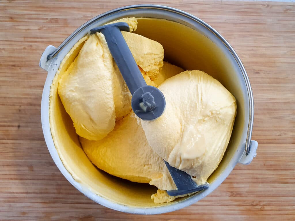 Churned passion fruit ice cream in churning bowl.