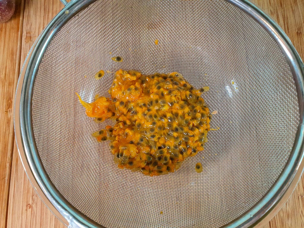 Passion fruit ice cream 6 Straining passion fruit pulp.