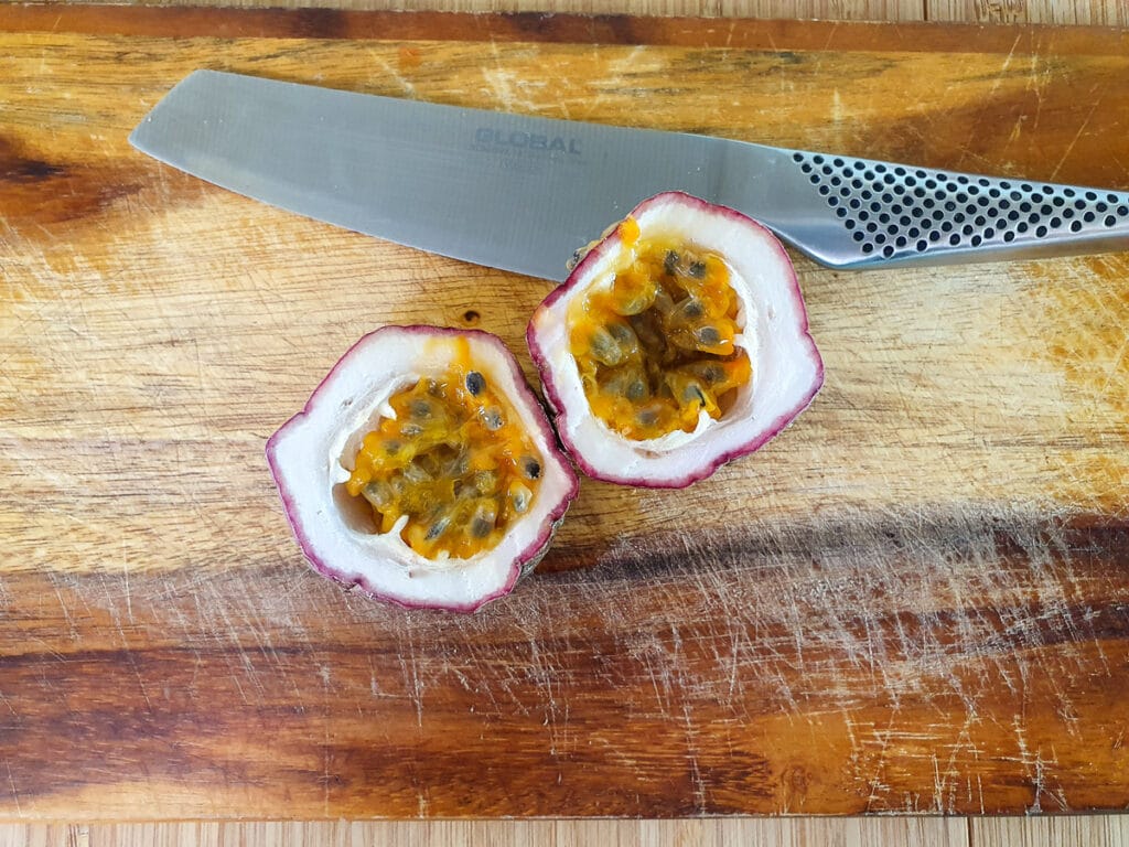 Sliced open passion fruit ready to scoop out pulp.