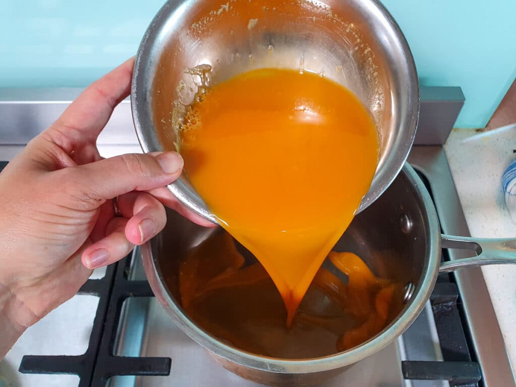 Passion fruit ice cream 7 Adding strained passion fruit to pot to reduce.