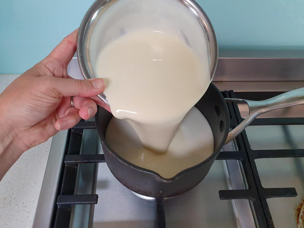 Passion fruit ice cream 10 Adding cream to pot on stove.