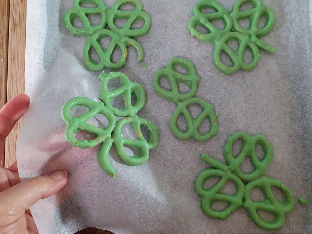 Peeling backing paper back from set pretzels.