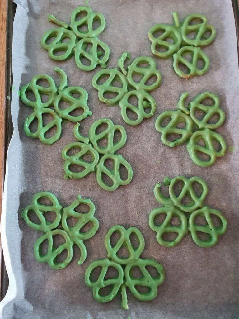 Chocolate coated pretzels drying on baking tray.