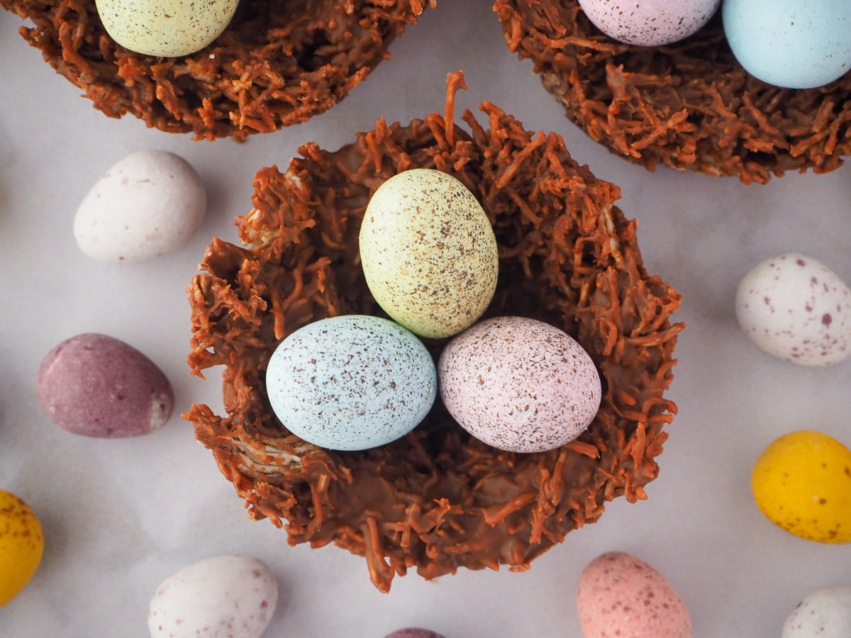 Top down view of shredded wheat nests surrounded by extra speckled Easter eggs