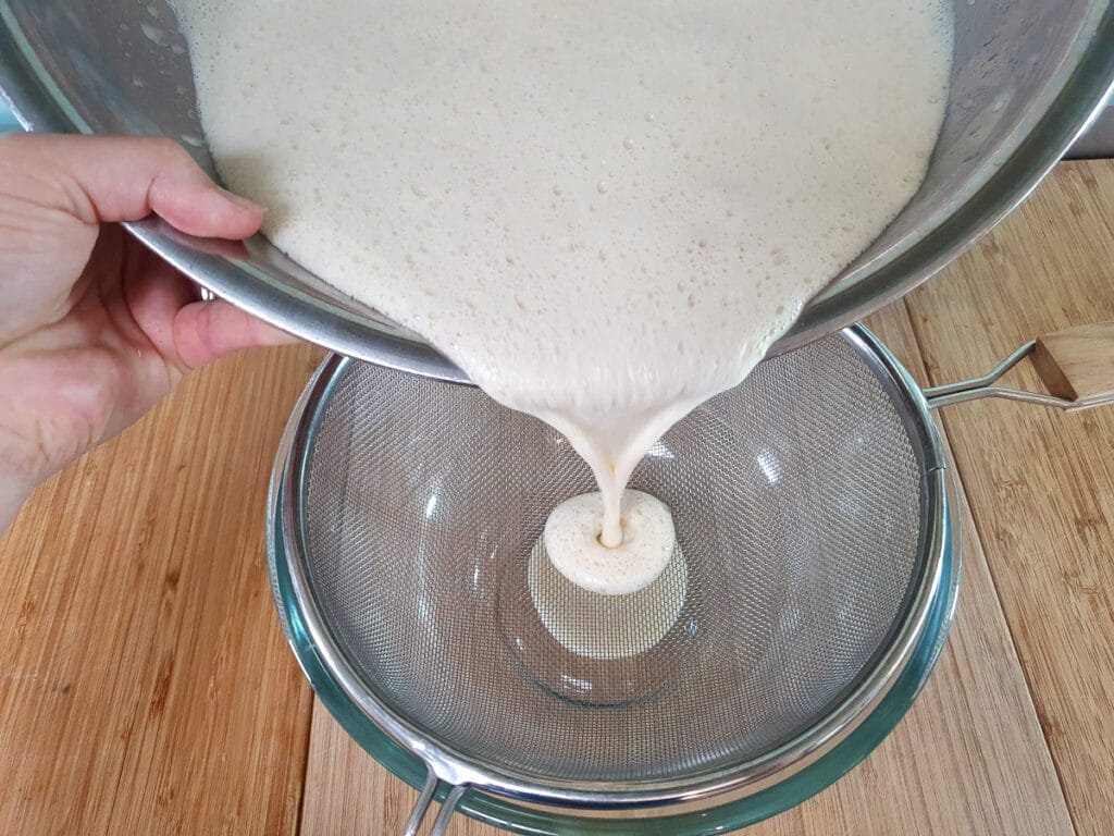 Straining ice cream mix.