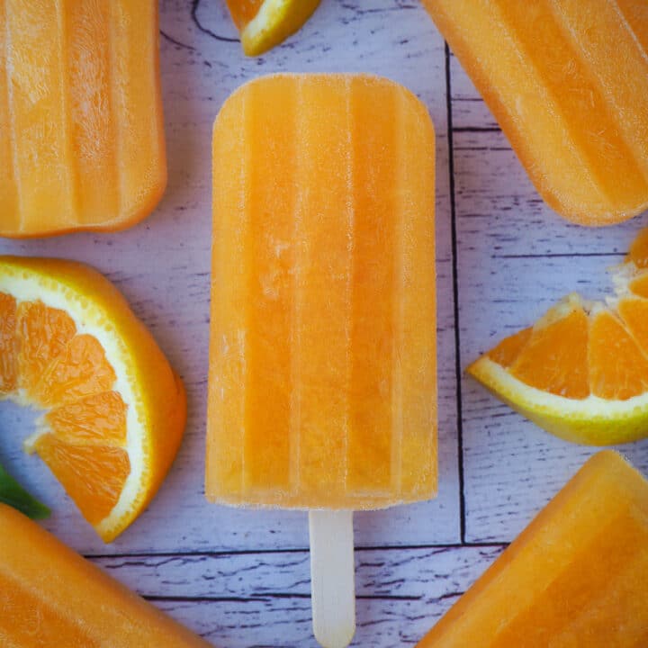 Close up orange popsicles with fresh oranges.